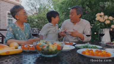 快乐的祖孙三人在庭院里用餐